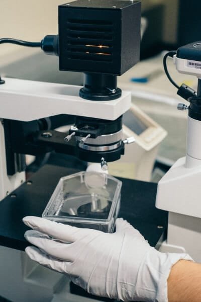 diagnostic lab hand with glove holding tools